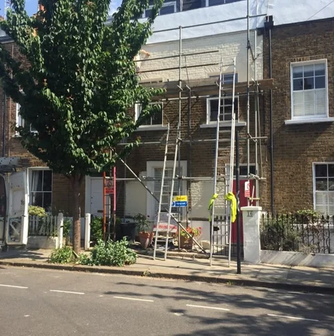 Before: Building frontage partly obscured by scaffolding and a tree.