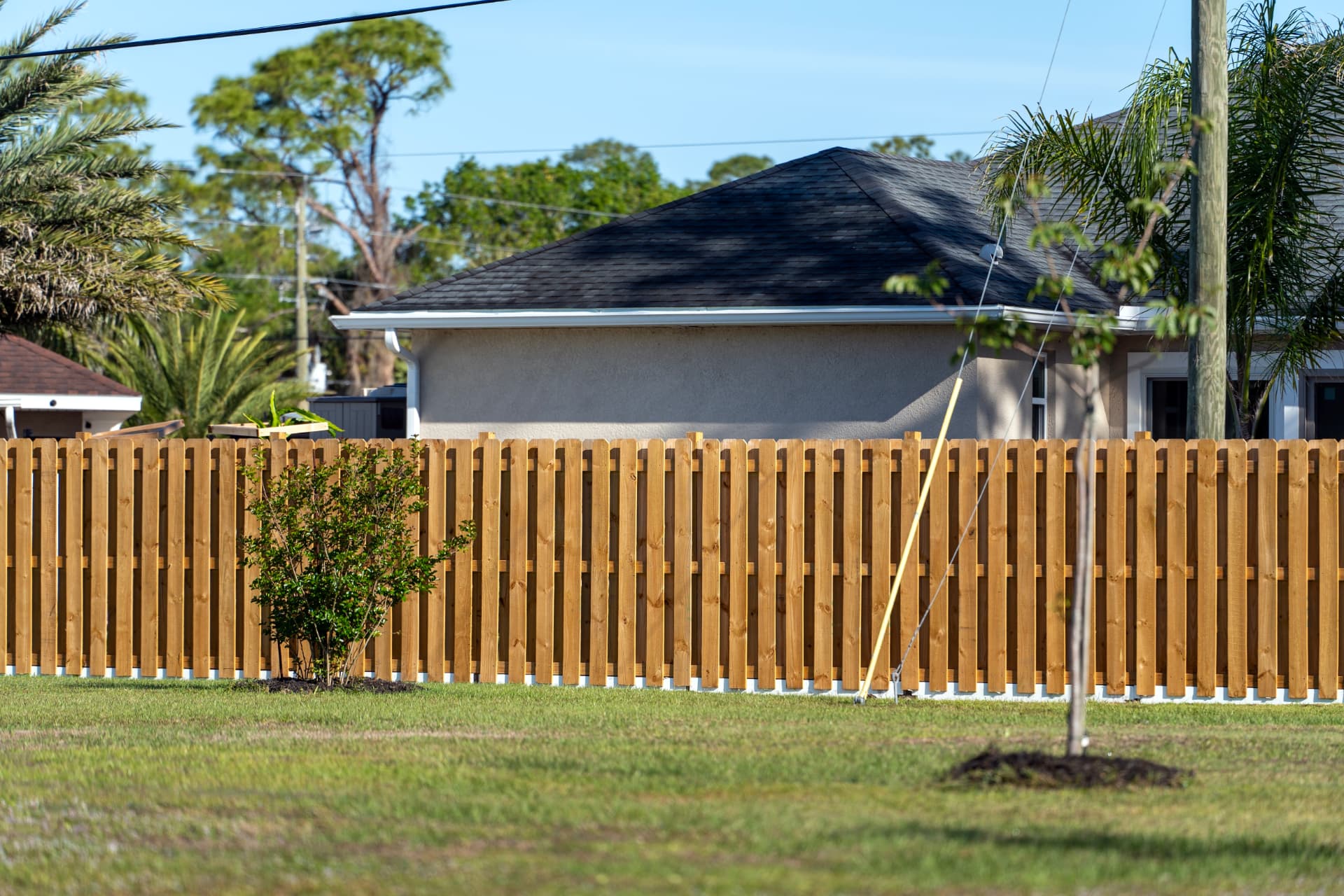 Timber boundary fence in front of a house and lawn